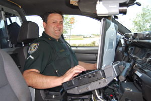 SUN PHOTO BY MERAB-MICHAL FAVORITE Deputy First Class Ryan White verifies that the numbers and the driver match the information in the Veri-Plate database. The system can scan license plates even at speeds of 75 mph. 